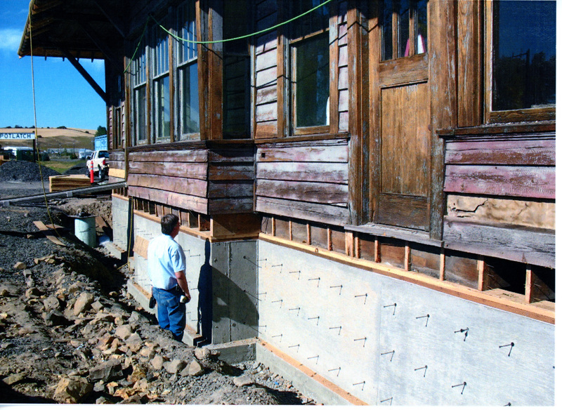 Photograph of a man inspecting the new foundation of the WI&M Depot.
