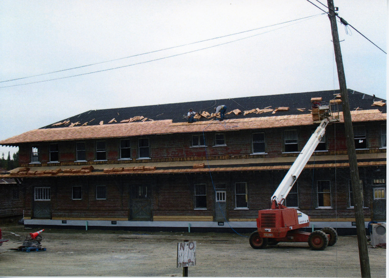 Photograph of men placing shingles on the roof of the Wi&M Depot.