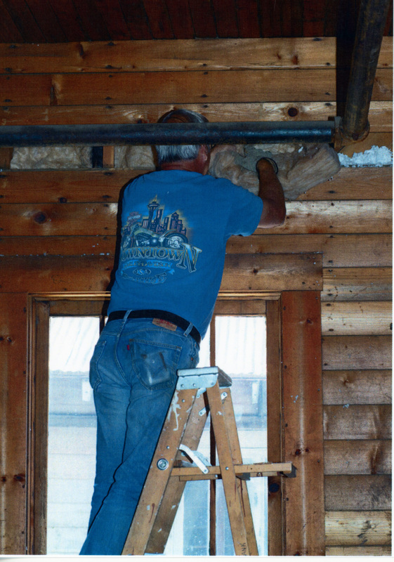 Photograph of man installing insulation in the WI&M Depot.