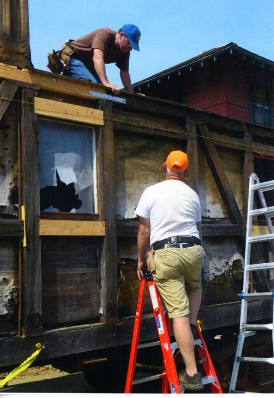 Photograph of men beginning the restoration of the Caboose X-5.