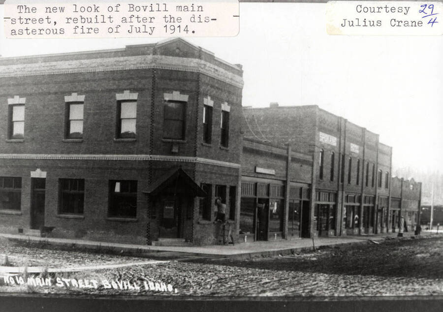 View of Main Street in Bovill after it was rebuilt after the disastrous fire in July of 1914. A person can be seen working in the window of a building.