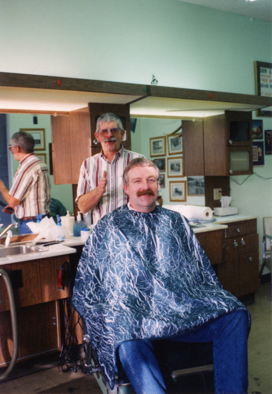 Photograph of Johnny Wolheter cutting Ivan Roynal;s hair. Johnny"s last haircut.