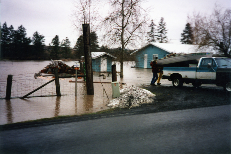 Photograph of men unloading a boat during a flood around Potlatch