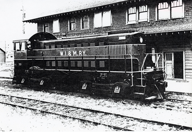 Photograph of WI&M Railway Locomotive #30 in front of the depot.