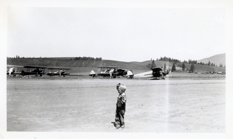 Photograph of a boy watching the airplanes ready to spray for the tussock moth.
