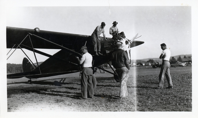 Photograph of Gordon Ellis and Wayne Cooper by an airplace ready to spray for the tussock moth.