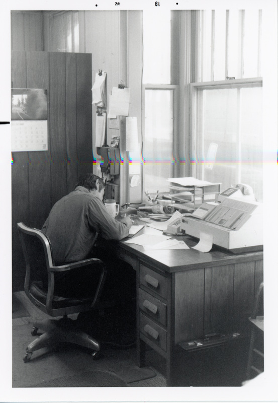 Photograph of a man sitting at a desk in the WI&M Depot.