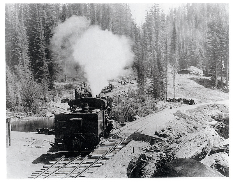Photograph of a three-truck PFI Heisler switching from the main Northern Pacific line to camps 4 and 5 spurs, one mile north of Pierce. A second Heisler is visible at Upper right.