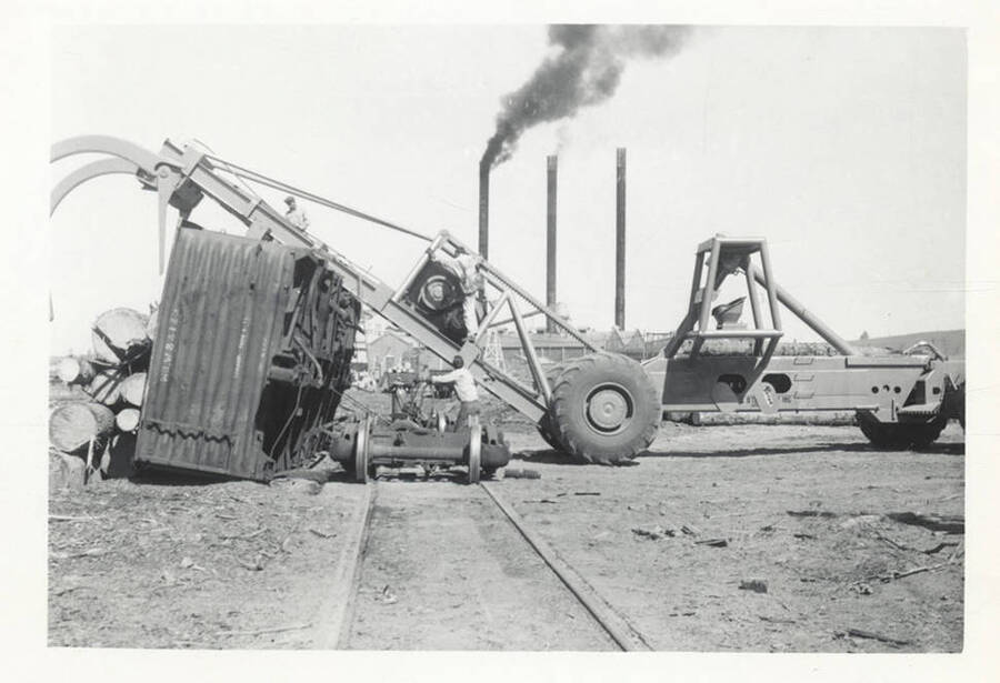 A railroad car that was once filled with logs after it was tipped over by the LeTourneau log unloading machine.