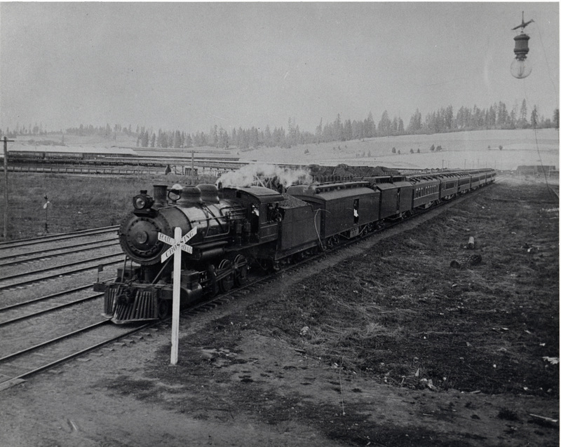 Special train (#21) brings Baron and Barones Shibusawa of Japan into Potlatch in 1909. The passenger equipment does not belong to the WI&M. Two gondolas sit on the coal trestle in the background.