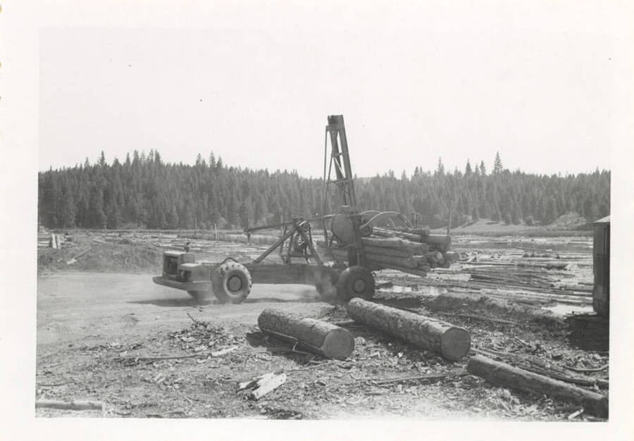 A full picture of the LeTourneau log unloading machine with grappling-like hooks.