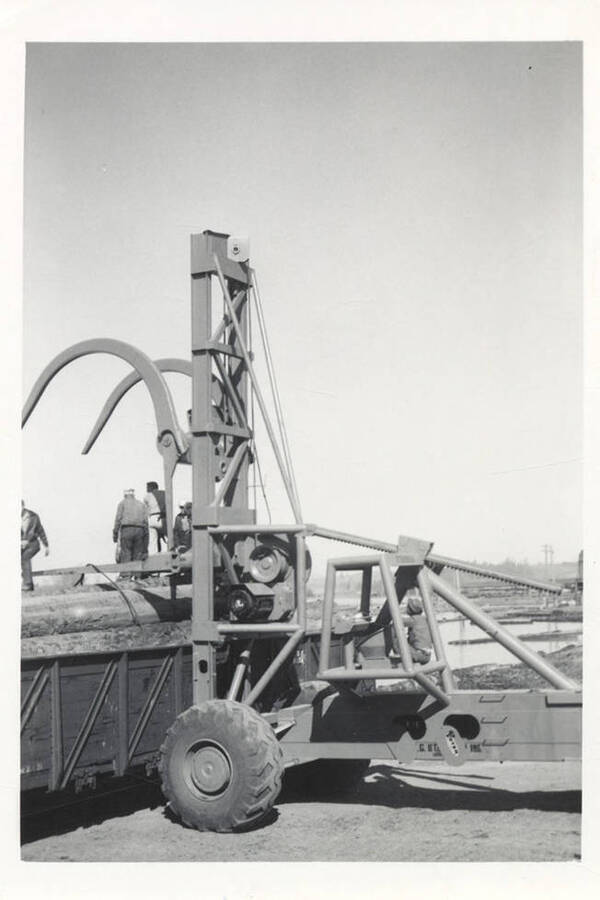 View of the driver and mechanics of the LeTourneau log unloading machine.