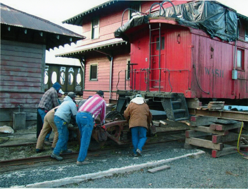 Photograph of installing freight trucks under the Caboose X-5 at the WI&M Depot in Potlatch.