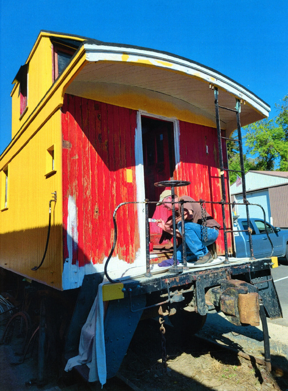 Photograph of Roger Farrell painting door frames on the Caboose X-5 at the WI&M Depot in Potlatch.