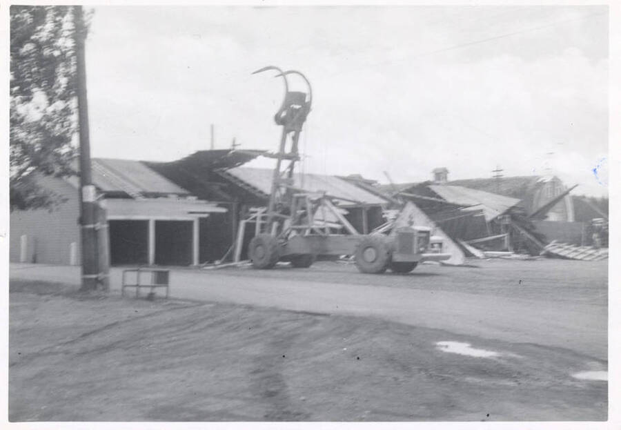 The LeTourneau log unloading machine taking the roof off of a structure.