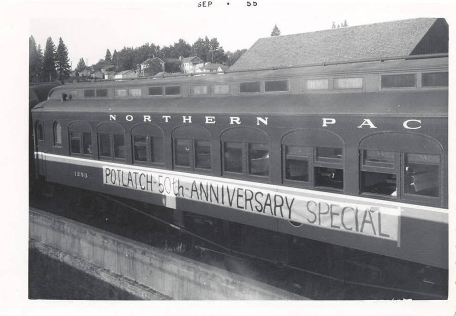 A photograph of a banner for the Potlatch 50th Anniversary Special on a Northern Pac train car.