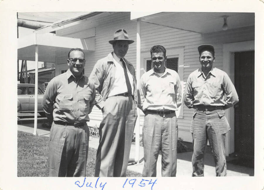 Four men in front of a building.