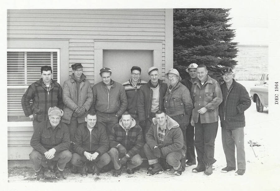 A group of thirteen men in coats to combat the cold weather.