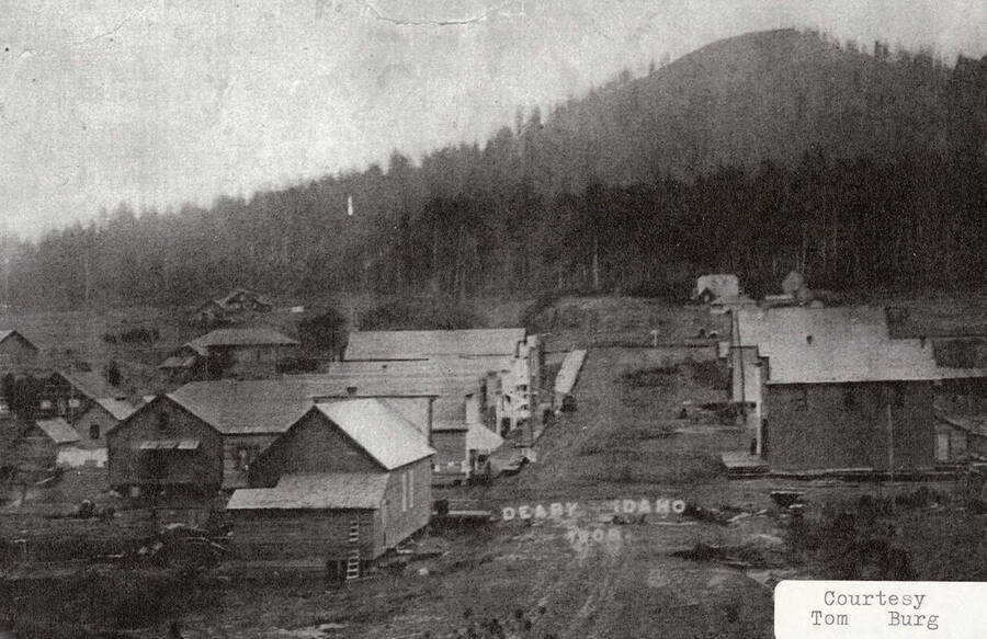 View of Deary, Idaho. Many buildings can be seen all around the town and a hill can be seen in the background.