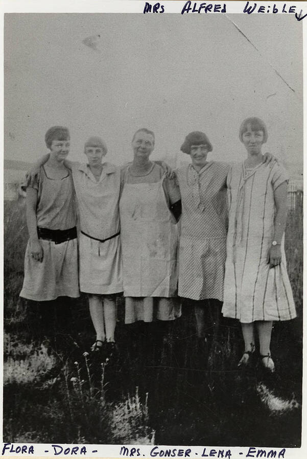 Flora, Dora, Mrs. Gonser, Lena, and Emma (Mrs. Alfred Weible) posing together in a field.
