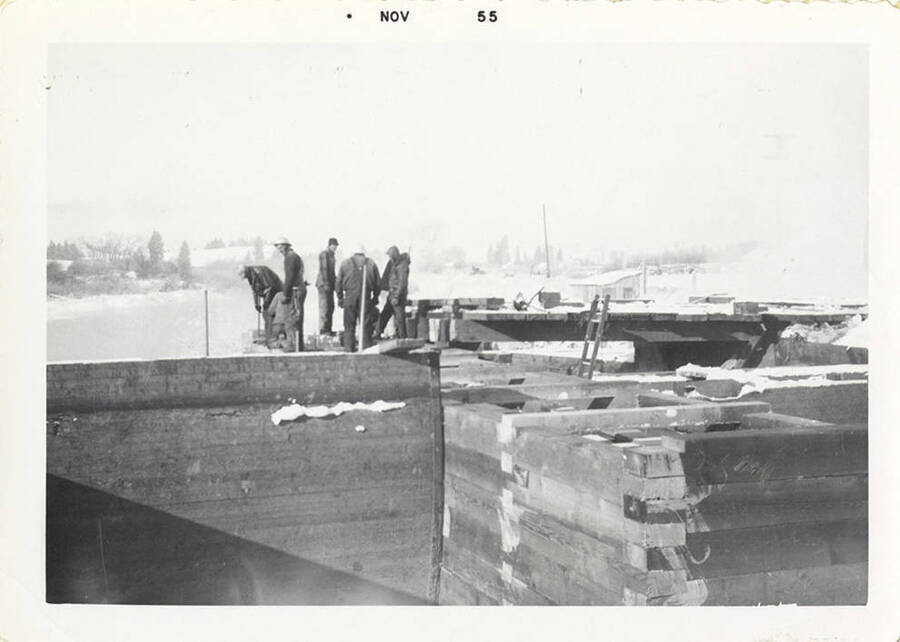 Five men working on top of the dam.