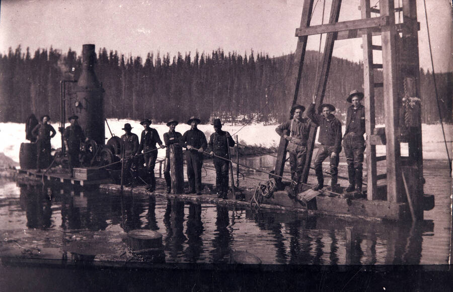 Ten employees on equipment on the log pond.