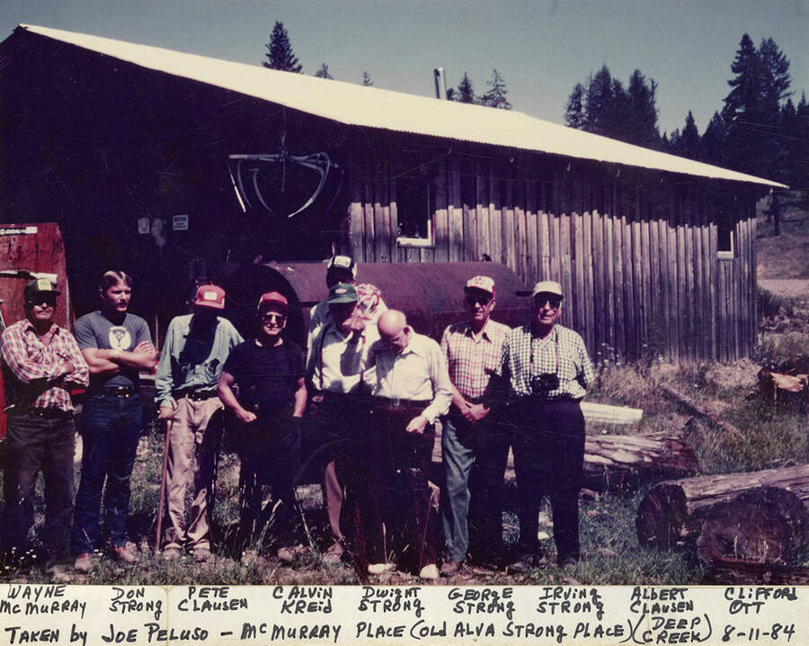 Wayne McMurray, Don Strong, Pete Clausen, Calvin Kreid, Dwight Strong, George Strong, Irving Strong, Alber Clausen, and Clifford Ott in a photograph taken by Joe Peluso at the Wayne McMurray Place (old Alva Strong Place) in the Deep Creek area of Idaho.