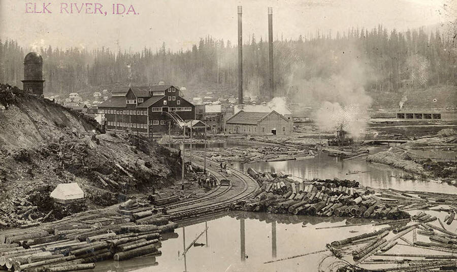 A photograph of the Elk River Mill in Elk River, Idaho from the view of the log pond.