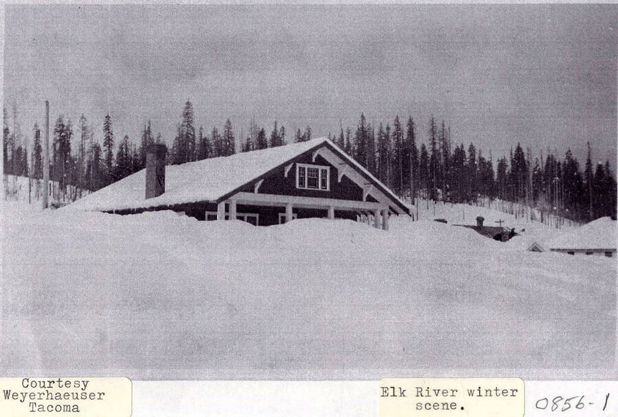 A photograph of a home in Elk River, ID buried in several feet of snow during the winter.