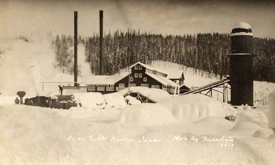 A photograph of the sawmill in Elk River, Idaho during a snowy winter.