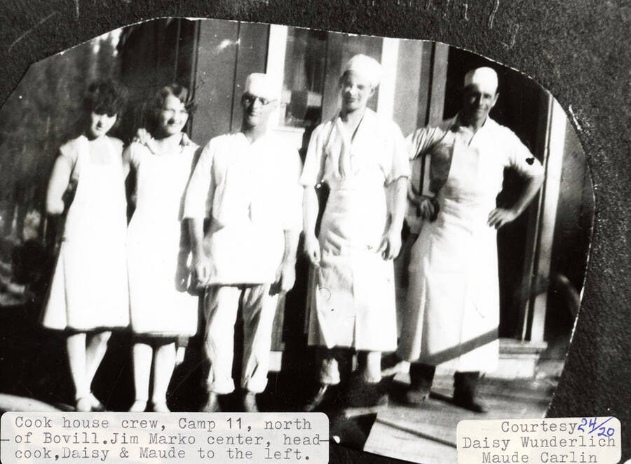 The cook house crew at Camp 11, which is located north of Bovill, Idaho. Jim Marko, the head cook, is standing on the center and Daisy and Maude are standing to his left.