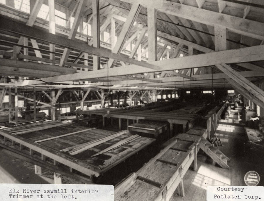 A photograph of the interior of the Elk River sawmill with a trimmer at the left of the photo.