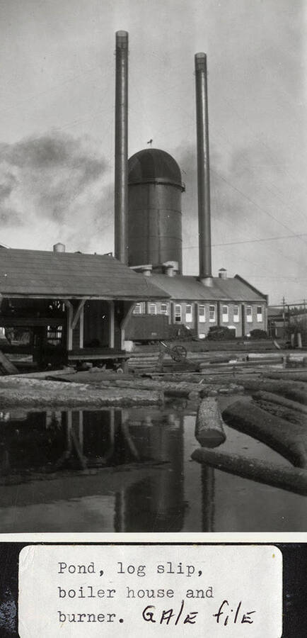 A photograph of the pond, log slip, boiler house, and burner at the Potlatch Lumber Company.