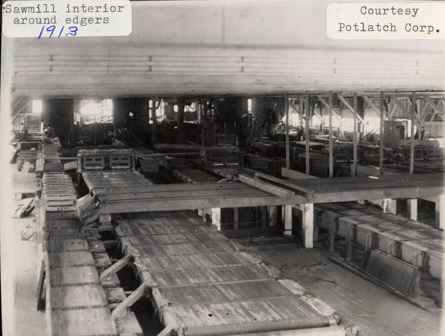 A photograph of the sawmill interior around edgers.