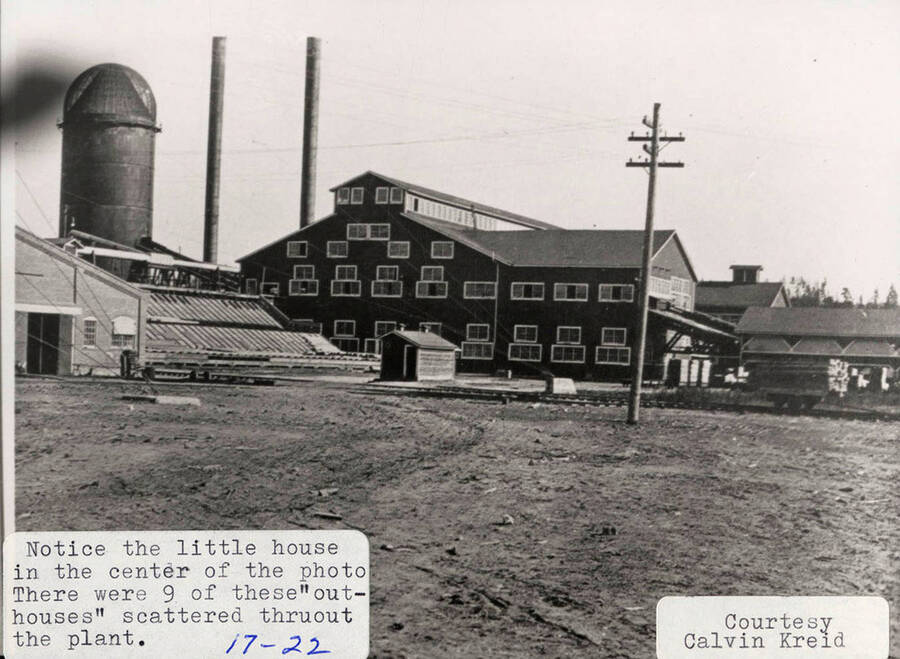 A photograph of the mill at potlatch but with a view of a one of the nine out houses scattered throughout the plant