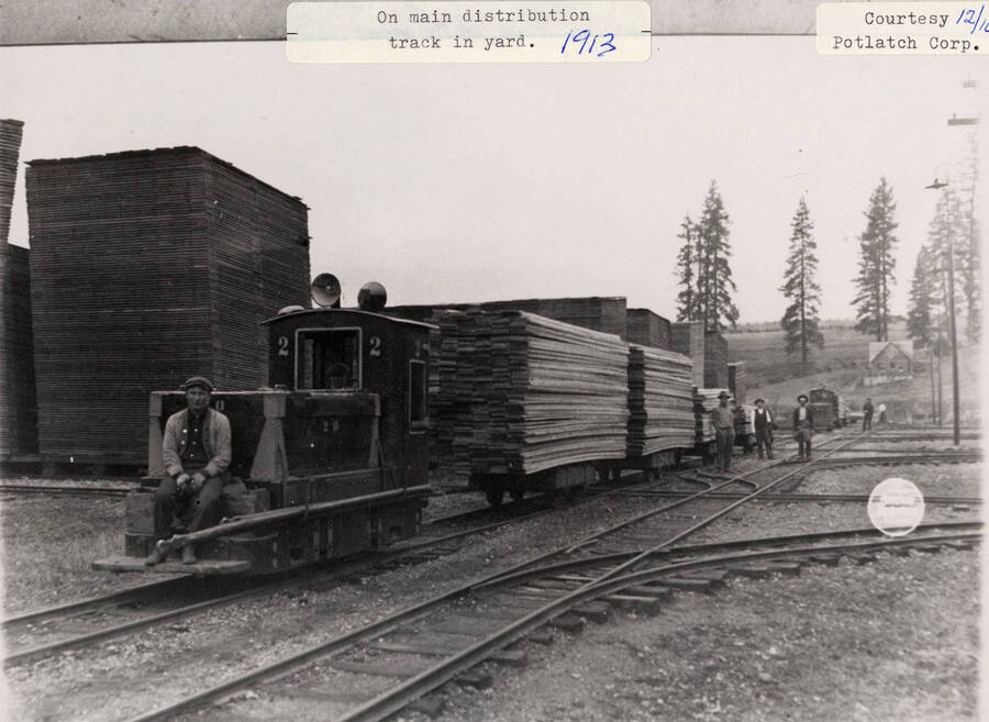 A photograph of a man on the main distribution track in the lumber yard.