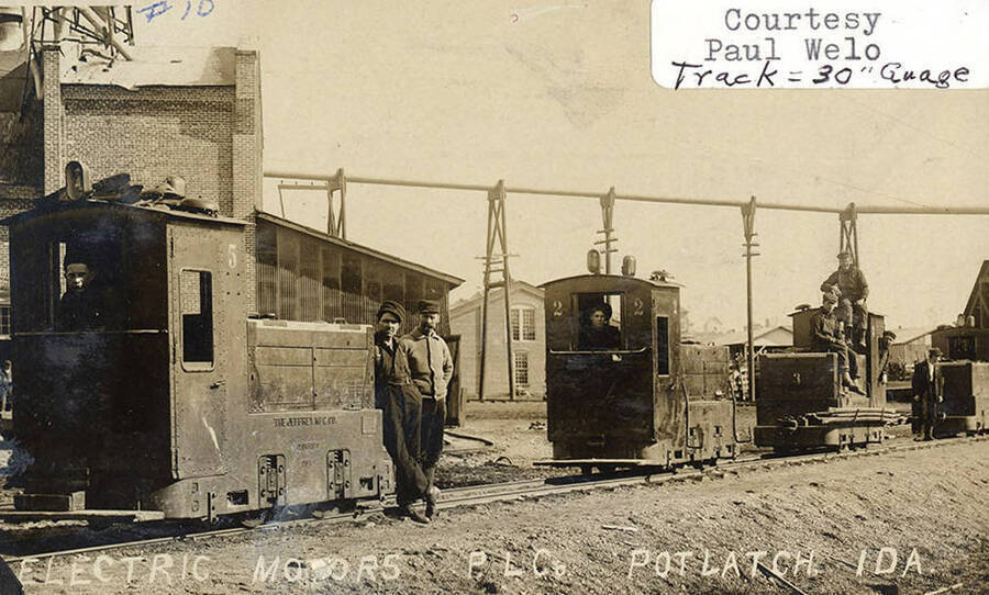 A photograph of employees in train cars on a 30' gauge track with electric motors at the Potlatch Lumber Company.
