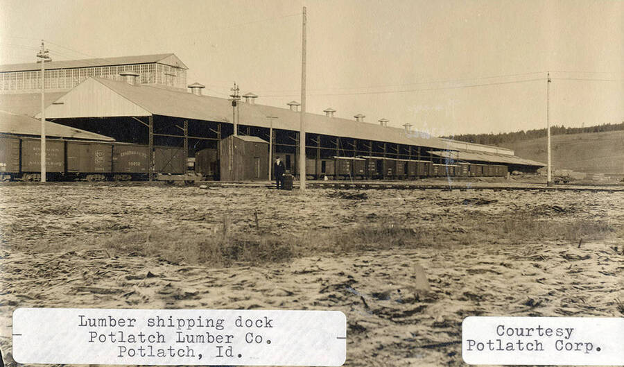 A photograph of the outside of the lumber shipping dock in Potlatch, Idaho for the Potlatch Lumber Company.