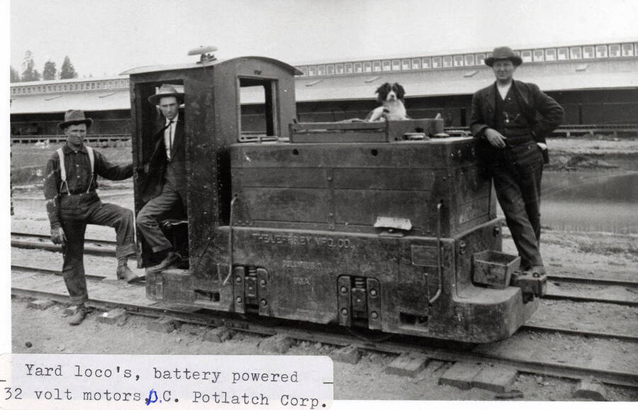 A photograph of employees and dog with the yard loco's battery bowered 32 volt motors.