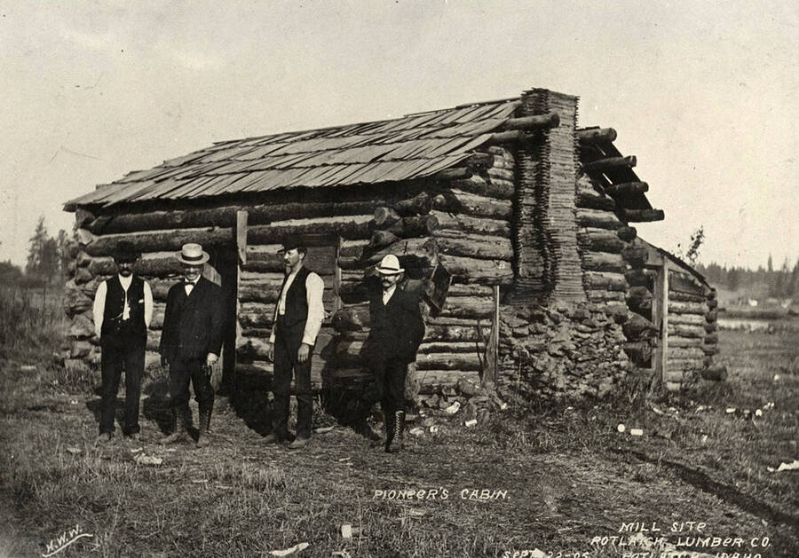 A photograph of pioneers with their cabin at a mill site for the Potlatch Lumber Company.