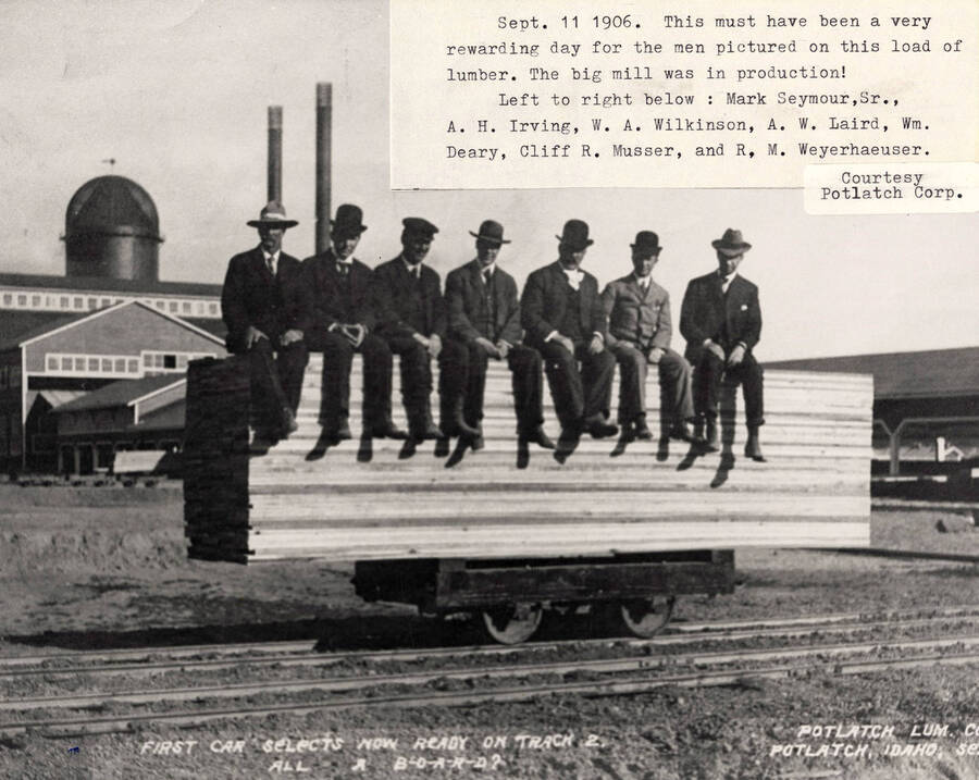 A photograph of Mark Seymour Sr., A.H. Irving, W.A. Wilkinson, A.W. Laird, Wm. Deary, Cliff R. Musser, and R. M. Weyerhaeuser on a car the first day of mill production.