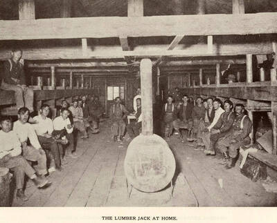 A photograph of a large group of lumber jack at home after a days work.