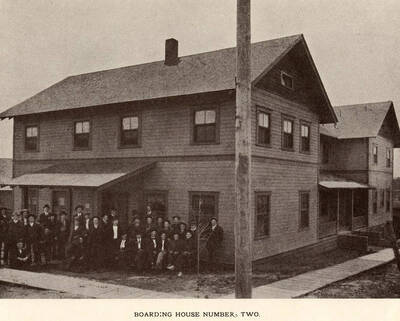 A photograph of boarding house number two with its residents.