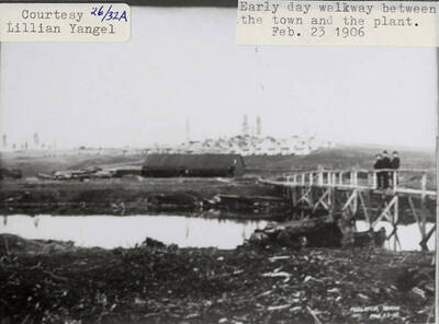A photograph of an early day walkway between the town and the plant.