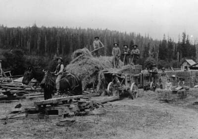 Bysegger hay baler on the Bysegger place. From left to right: Elwood Hicks, Willie Bysegger, George Teas, Ed Soncarty, John Bysegger, Grandpa (Fred) Bysegger, Charley Bysegger, Clara and Eddie Bysegger sitting on bales.