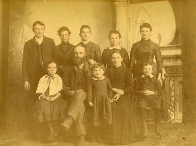 Family portrait for the Allen families. Names read as subjects appear, left to right, front to back: Springmire, Mary; Allen, Edward S.; Allen, Sopha Esther; Allen, Adelaide Teas; Allen, Frankie; Allen, Charley; Allen, Carrie Chamberlin; Nirk, Bertha; Allen, Olive Craig; Allen, Flora Price.