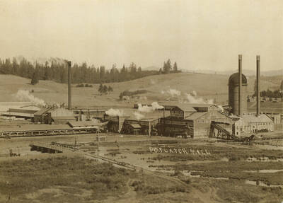 Photo of the Potlatch mill in 1913, hills and trees in background