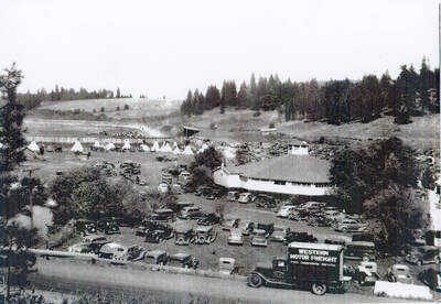 View of Riverside Park with round house, race track and parked cars.