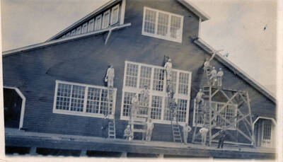 A group of men paints the Potlatch Mill.