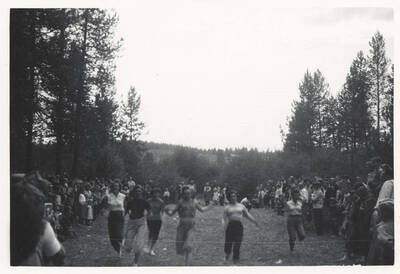 Women running towards a finish line at the end of a race.